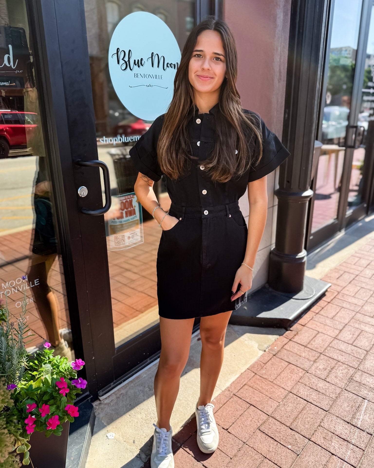 Woman in a black outfit standing outside a store with 'Blue Moon' branding.
