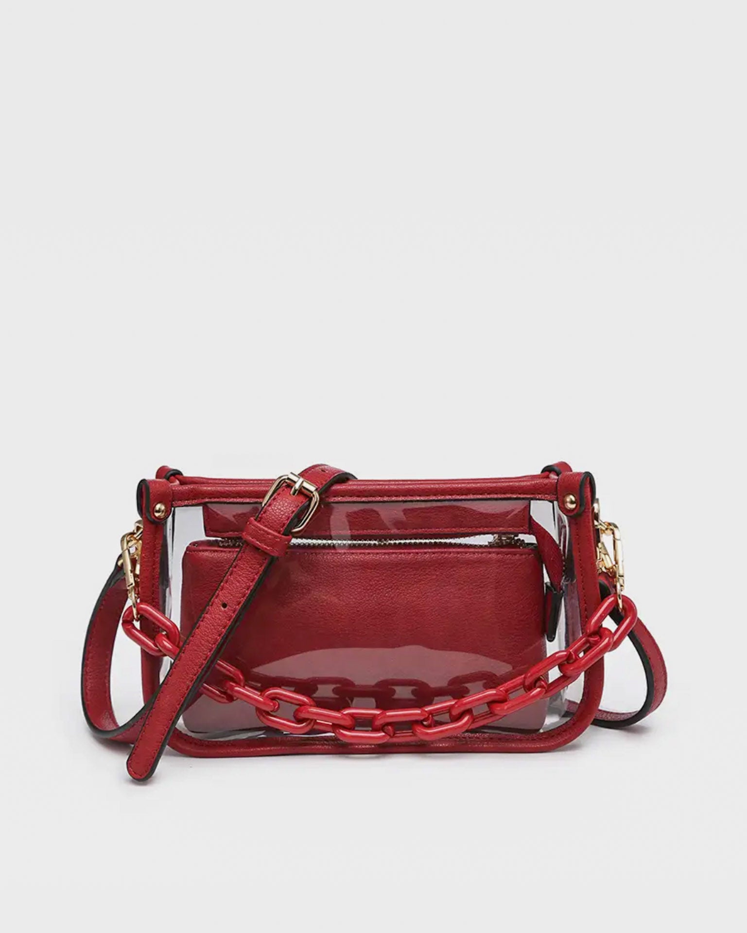 Red handbag with clear section and chain detail on a light gray background