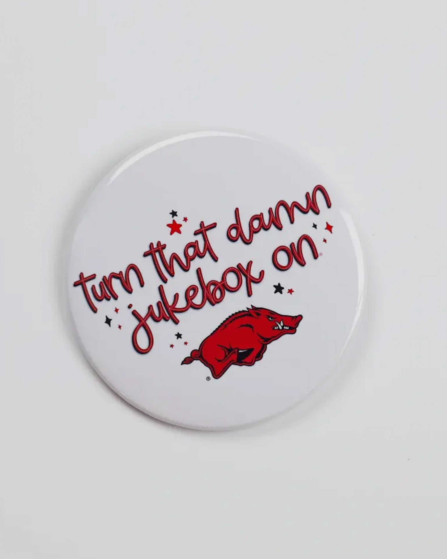 Round button badge with text 'Turn that damn jukebox on' and a red Hog on a white background