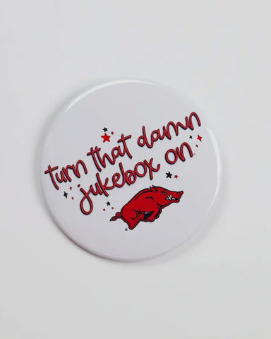 Round button badge with text 'Turn that damn jukebox on' and a red Hog on a white background