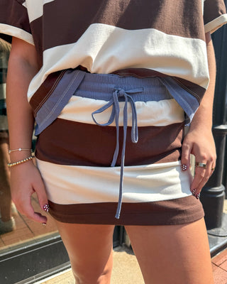Close-up of coco striped skort with drawstring waist, worn with an oversized striped top outside Blue Moon Bentonville storefront