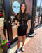 Woman in a black outfit standing outside a store with 'Blue Moon' branding.