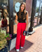 Woman in black top and red pants standing outside a store with 'Blue Moon' branding.