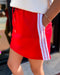 Red skirt with white stripes worn by a person, blurred background