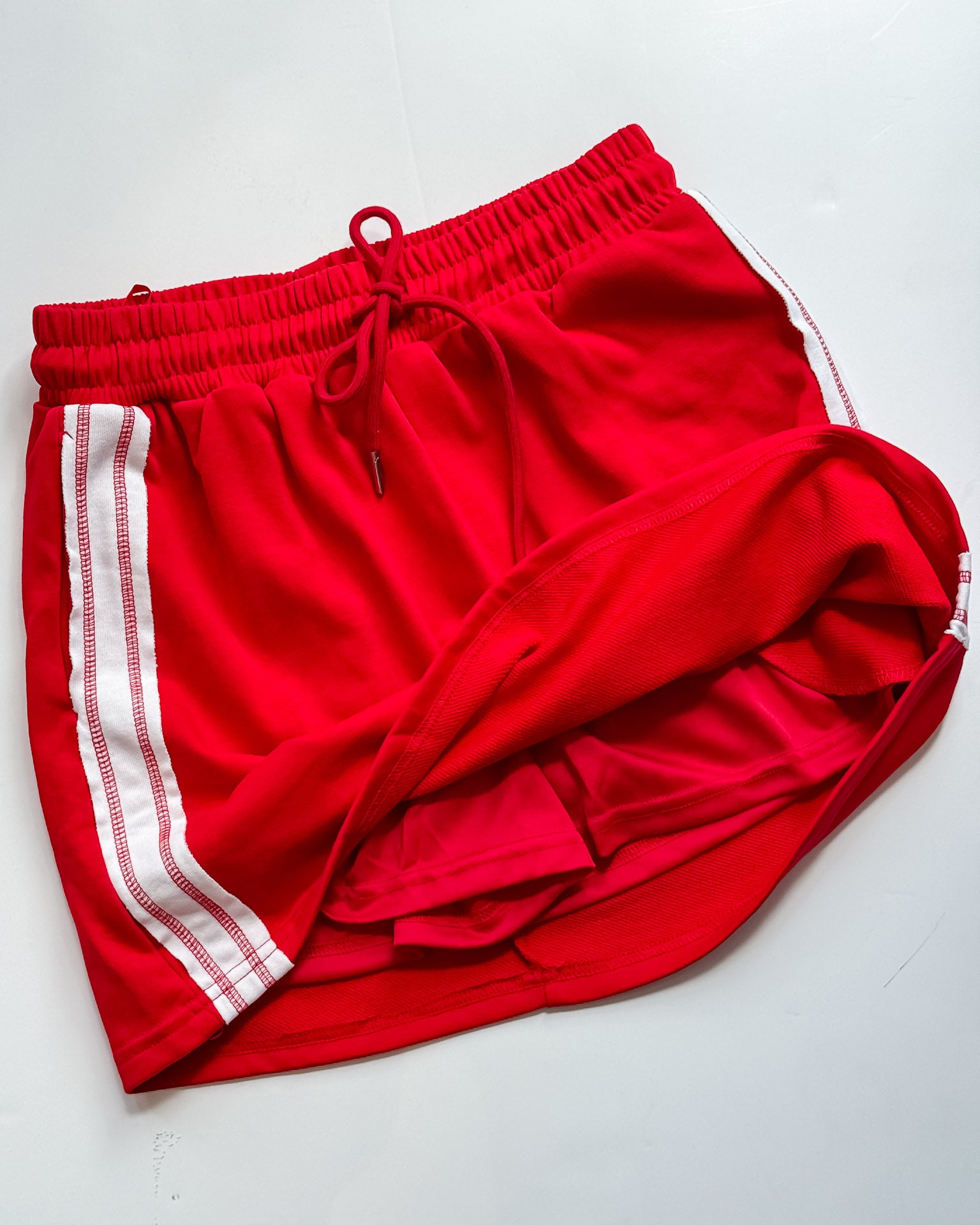 Red shorts with white stripes on a white background