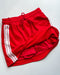 Red shorts with white stripes on a white background