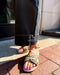 Person wearing a sandal on a brick surface