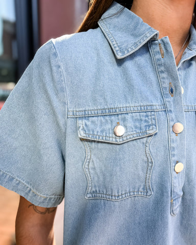 Light blue denim shirt with button details on a blurred background