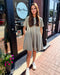 Woman in a light green dress standing outside a store named 'Blue Moon'.