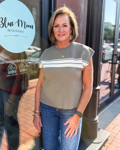 Woman standing in front of a store with 'Blue Moon Bentonville' branding.