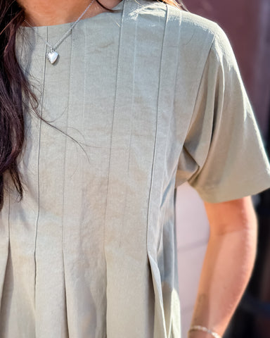 Person wearing a light-colored shirt with a blurred background