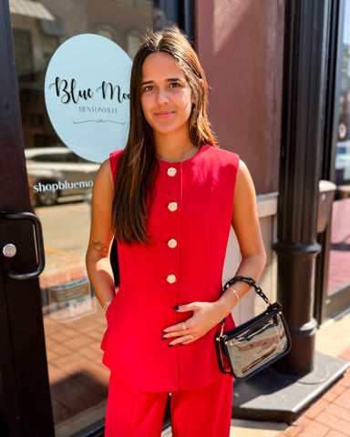 Woman in a red outfit standing outside a store with 'Blue Moon' branding.