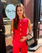 Woman in a red outfit standing outside a store with 'Blue Moon' branding.