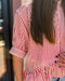 Person wearing a red and white striped shirt with a blurred background