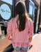 Person wearing a red and white striped shirt in front of a store with 'Blue Moon' branding.