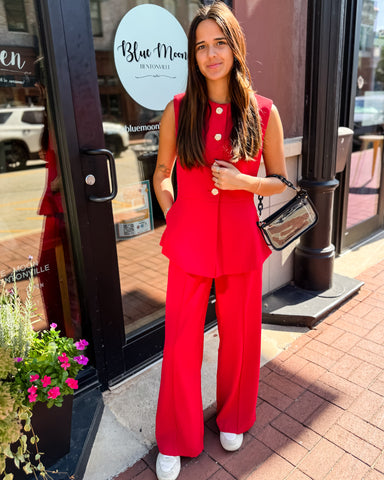Woman in a red outfit standing outside a store with 'Blue Moon' branding.