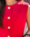 Red sleeveless top with gold buttons worn by a person.
