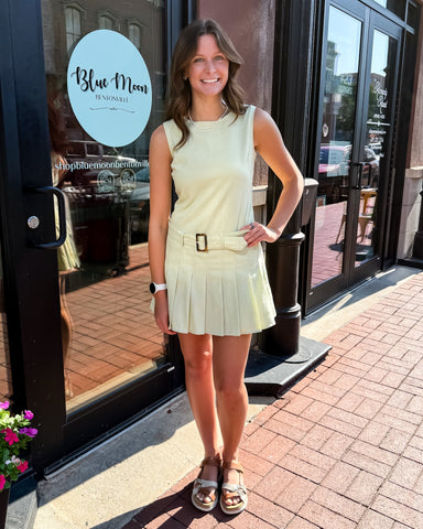 Woman in a light green dress standing outside a store with 'Blue Moon' branding.