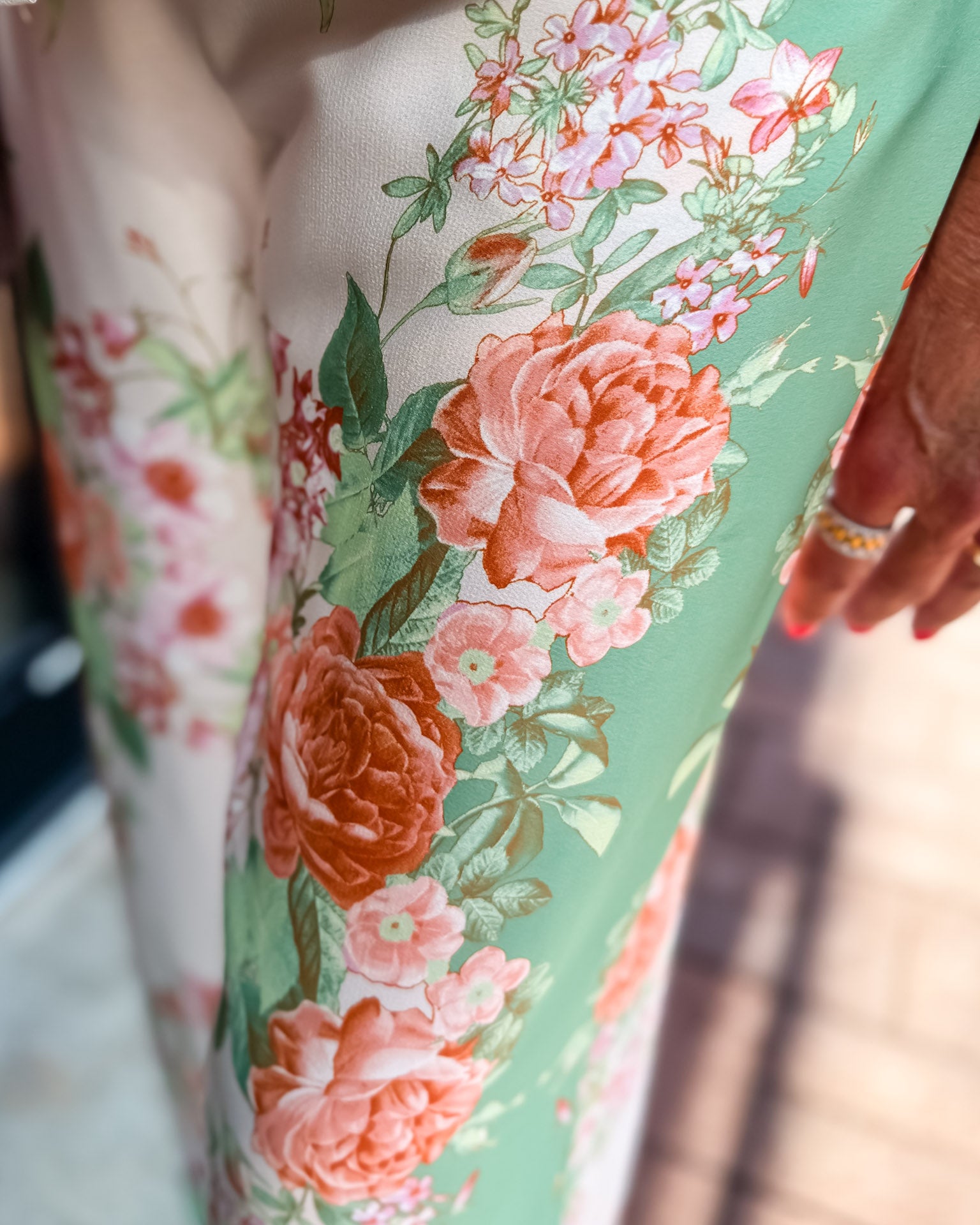 Floral-patterned fabric with pink and orange flowers on a green background