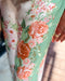 Floral-patterned fabric with pink and orange flowers on a green background