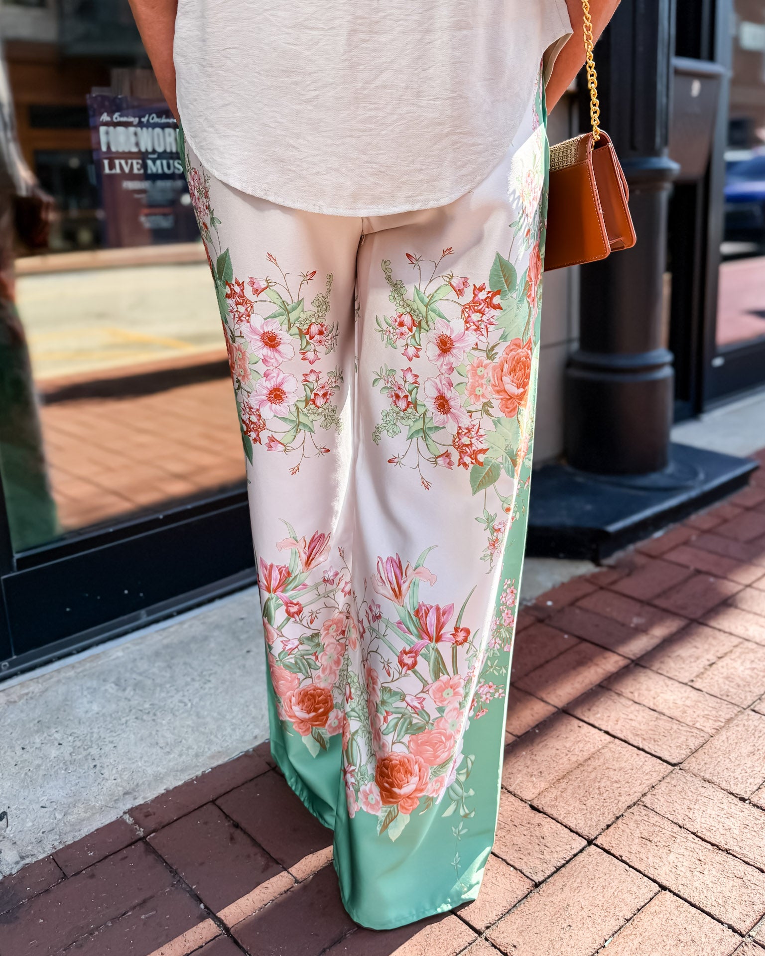 Person wearing floral-patterned pants on a sidewalk