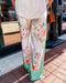 Person wearing floral-patterned pants on a sidewalk