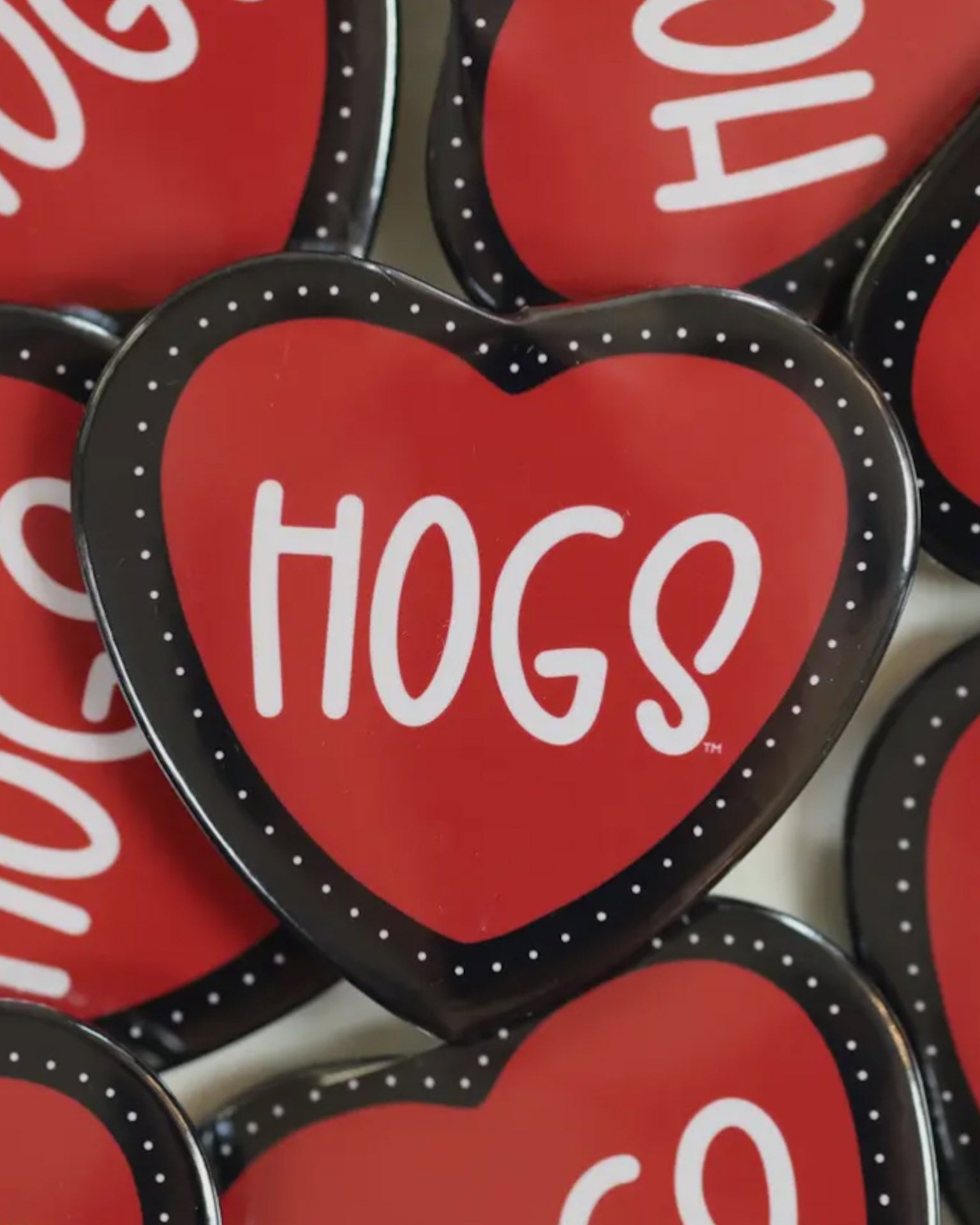 Red heart-shaped buttons with 'HOGS' text on a white background