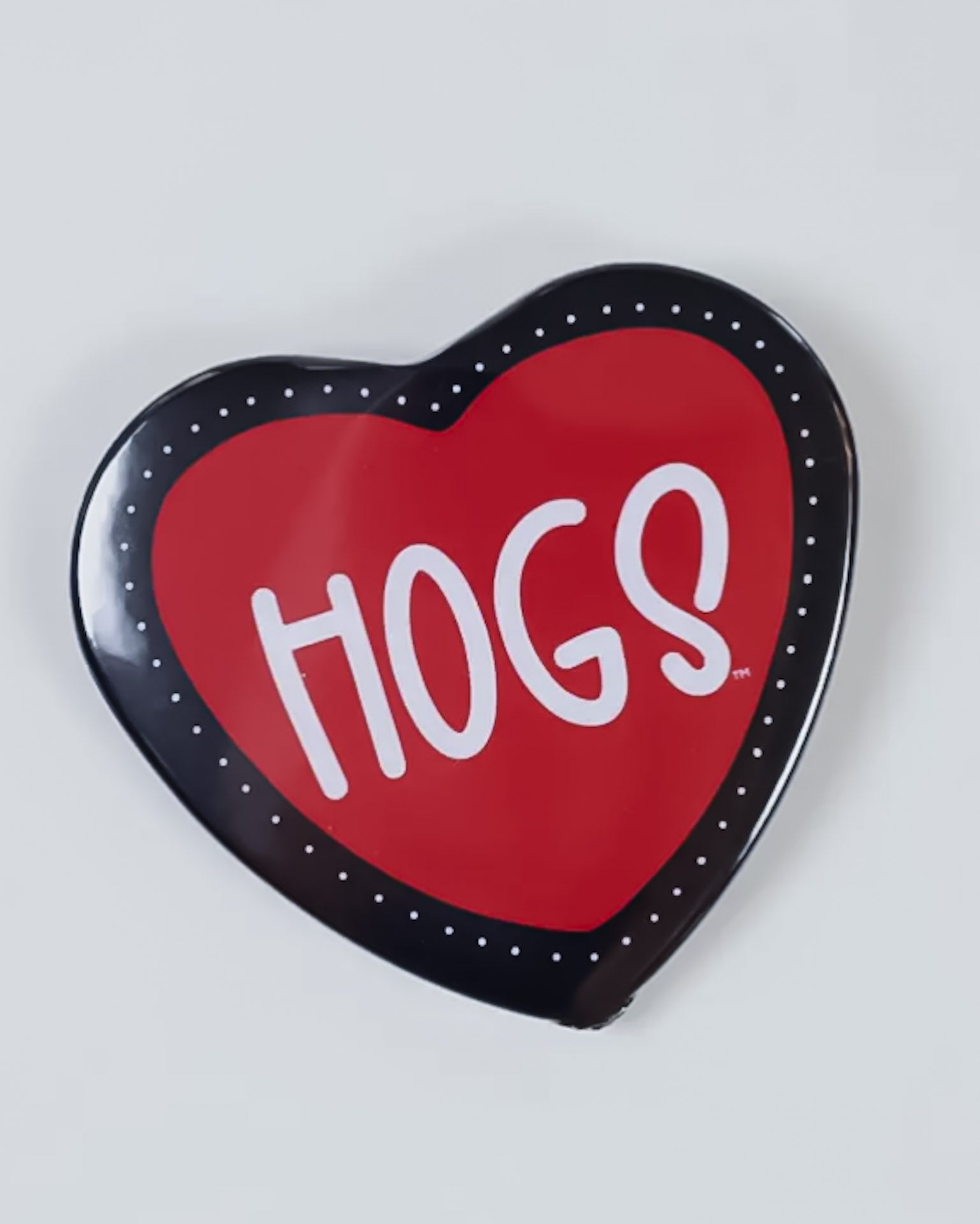 Heart-shaped button badge with 'HOGS' text on a white background