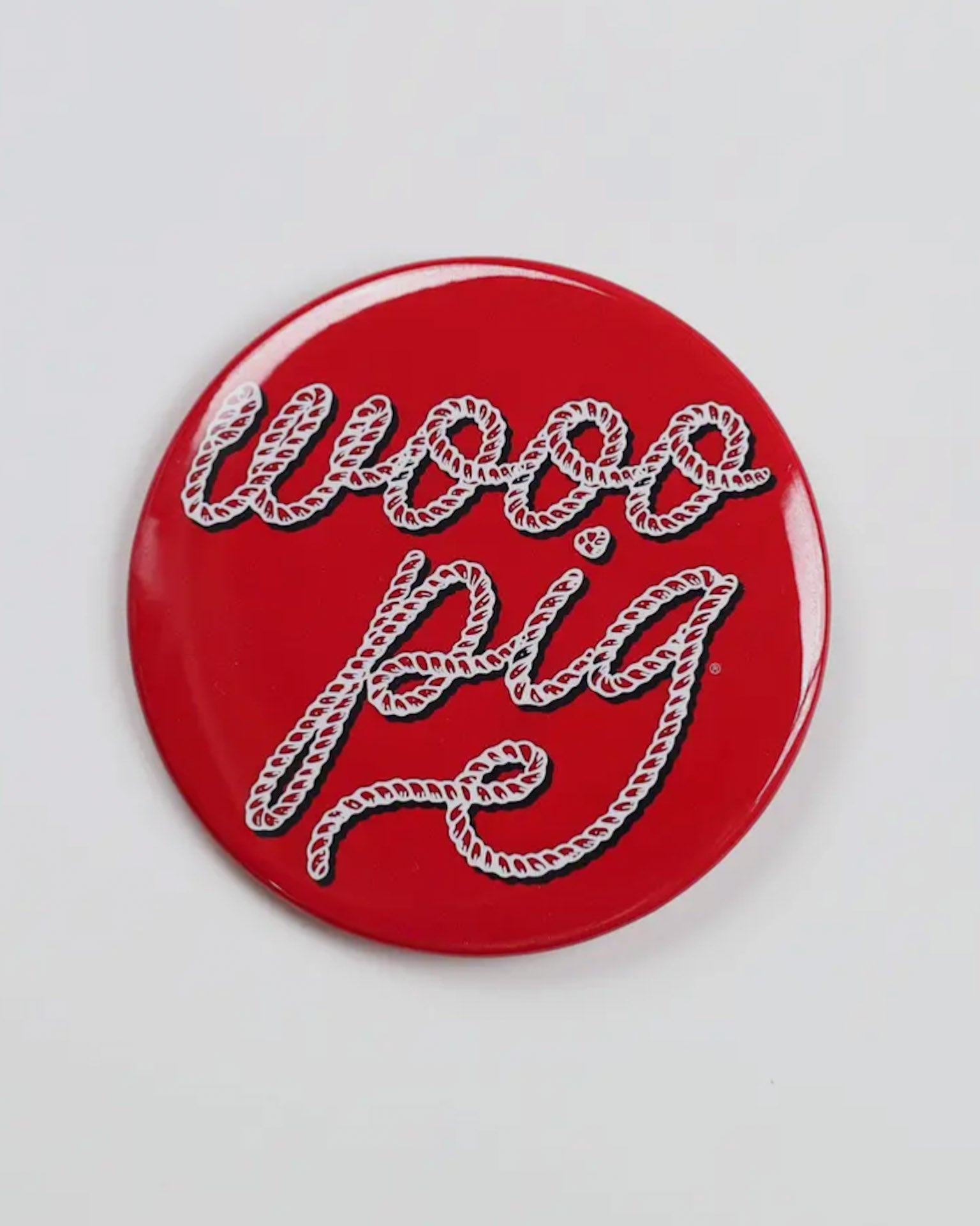 Red button badge with 'wooo pig' text on a white background