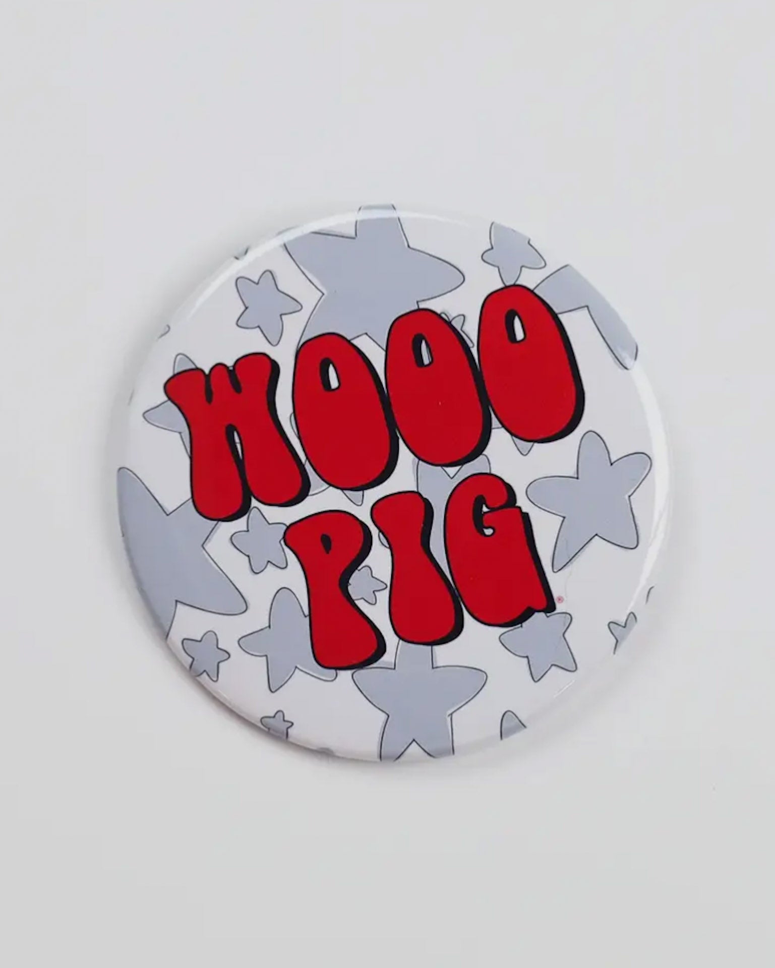 Button badge with 'WOOO PIG' text on a star-patterned background