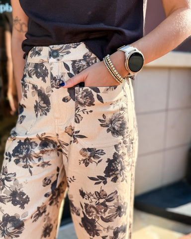 Person wearing floral pants with a blurred background