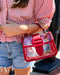 Person wearing a red and white striped shirt with a clear handbag featuring a red strap.