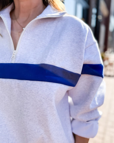 Person wearing a white and blue pullover with a blurred background
