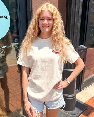 Woman wearing an ivory Comfort Colors Arkansas Razorbacks Wild Hogs graphic T-shirt with a small football logo on the front and a large vintage back graphic.