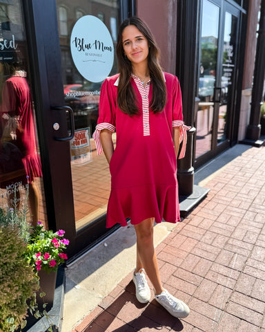 Woman in a red dress standing outside a store with 'Blue Moon' branding.