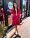 Woman in a red dress standing outside a store with 'Blue Moon' branding.