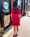 Woman in a red dress standing outside a store with 'Blue Moon' branding.